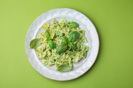 Delicious pasta with pesto sauce and basil on light green background, top viewの写真素材