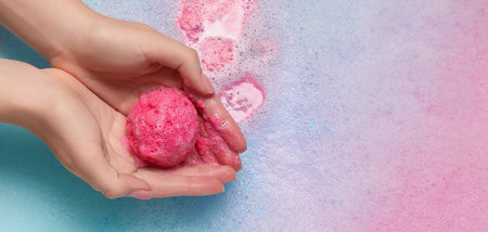 Woman holding bath bomb over foam, closeup. Banner designの写真素材