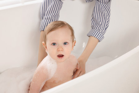 Cute little baby bathing in tub at homeの写真素材