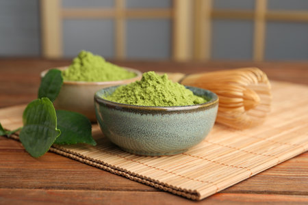 Green matcha powder and bamboo whiskey on wooden table indoors, closeupの写真素材