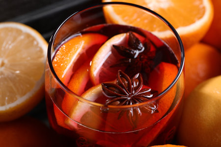 Glass of aromatic punch drink and fresh citrus fruits on table, closeupの写真素材
