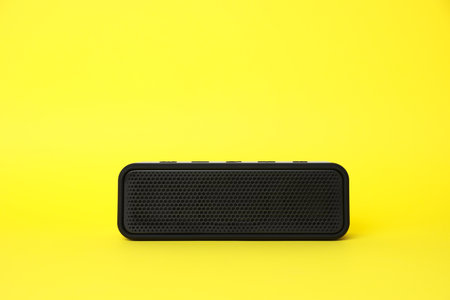 One portable bluetooth speaker on yellow background, space for text. Audio equipmentの写真素材