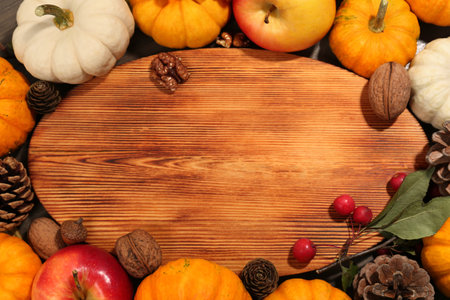 Thanksgiving day. Flat lay composition with pumpkins and wooden board on table, space for textの写真素材