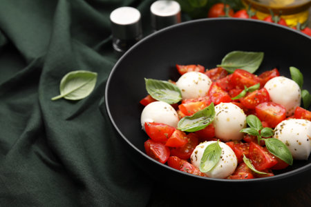 Tasty salad Caprese with tomatoes, mozzarella balls and basil on table, closeup. Space for textの写真素材