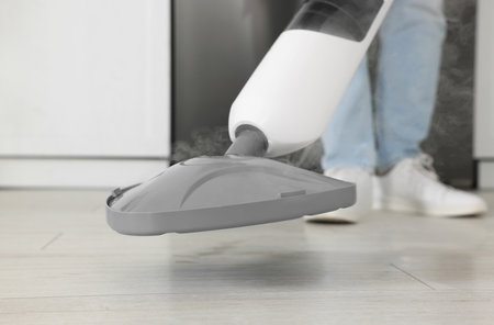 Man cleaning floor with steam mop at home, closeupの写真素材
