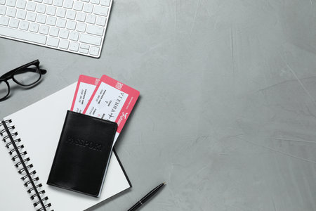 Flat lay composition with tickets, passport and notebook on light gray table, space for text....