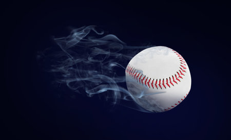Baseball ball flying leaving smoke after on black backgroundの写真素材