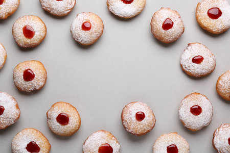 Frame of Hanukkah donuts with jelly and powdered sugar on light gray background, flat lay. Space for textの写真素材
