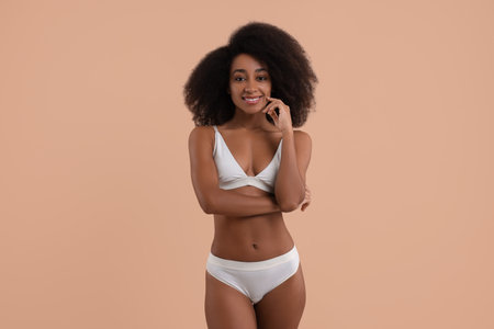Beautiful woman in stylish bikini on beige backgroundの写真素材