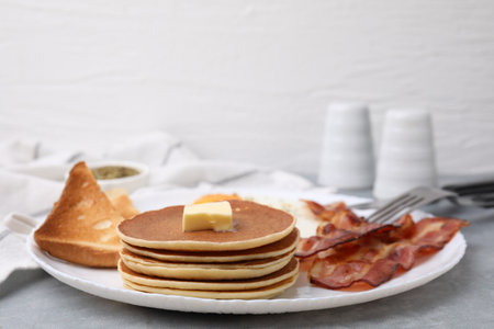 Tasty pancakes served with bacon on gray tableの写真素材