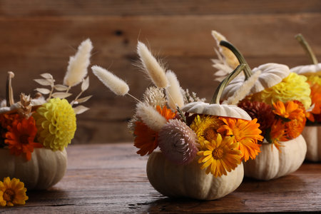 Composition with small pumpkins, beautiful flowers and spikelets on wooden table, closeupの写真素材