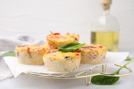 Freshly baked bacon and egg muffins with cheese on light gray table, closeup. Space for textの写真素材