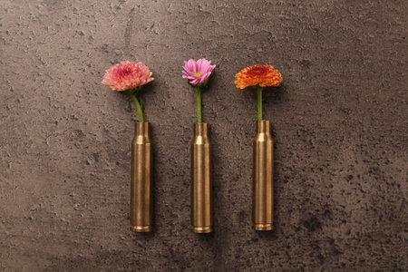 Beautiful flowers in bullet cases on gray textured table, flat layの写真素材