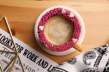 Flat lay composition with delicious edible biscuit cup of coffee decorated with sprinkles on wooden tableの写真素材