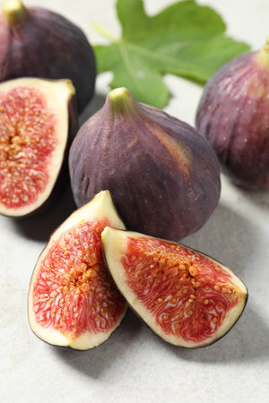 Fresh ripe figs and green leaf on light table, closeupの写真素材