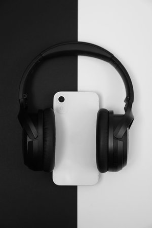 Modern wireless headphones and smartphone on color background, top viewの写真素材