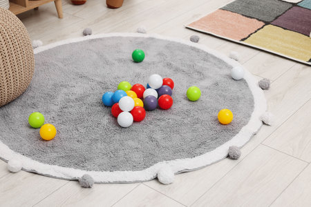 Bright toy balls and soft rug on floor in kindergartenの写真素材