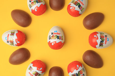 Sveti Vlas, Bulgaria - June 29, 2023: Kinder Surprise Eggs on orange background, flat lay