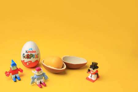 Sveti Vlas, Bulgaria - June 29, 2023: Kinder Surprise Eggs and toys on orange background, space for textのeditorial素材