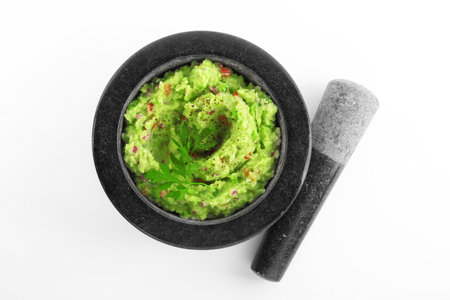 Mortar and pestle with delicious guacamole isolated on white, top viewの写真素材