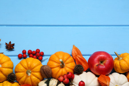 Thanksgiving day. Flat lay composition with pumpkins on light blue wooden table, space for textの写真素材