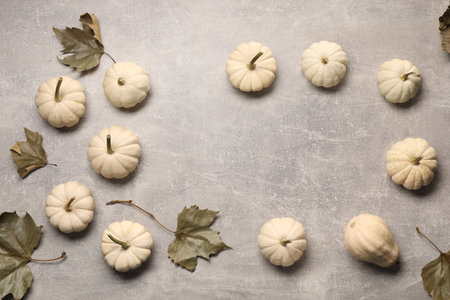 Flat lay composition with ripe white pumpkins on light gray table. Space for textの写真素材