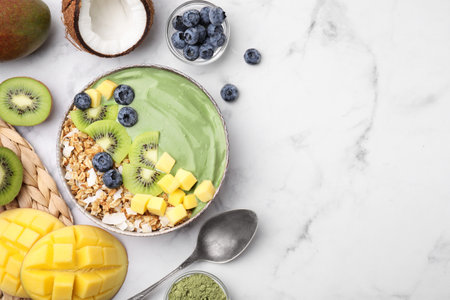Tasty matcha smoothie bowl with fresh fruits and oatmeal served on white marble table, flat lay with space for text. Healthy breakfastの写真素材