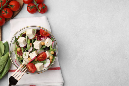 Tasty salad with tofu and vegetables served on light gray table, flat lay. Space for textの写真素材