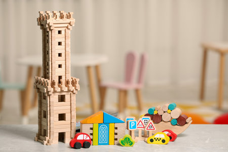 Set of wooden toys on light gray table indoors, space for text. Children's development