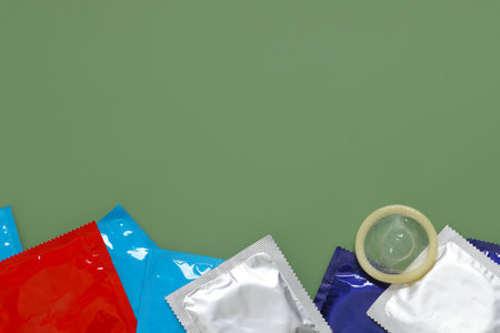 Packaged condoms on light green background, top view with space for text. Safe sexの写真素材