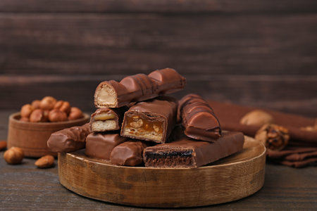 Pieces of different tasty chocolate bars on wooden table
