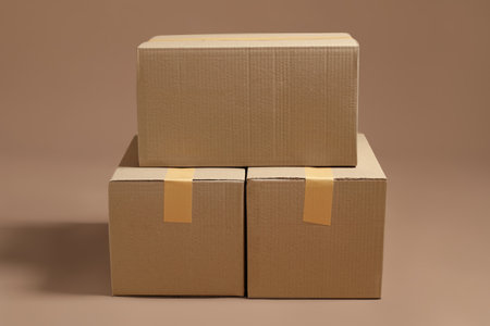 Stack of cardboard boxes on light brown backgroundの写真素材