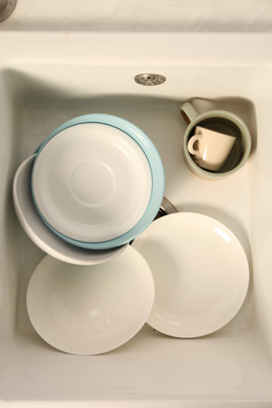 Clean tableware in white sink, top viewの写真素材