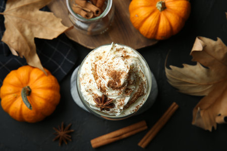 Flat lay composition with glass of pumpkin spice latte on black tableの写真素材