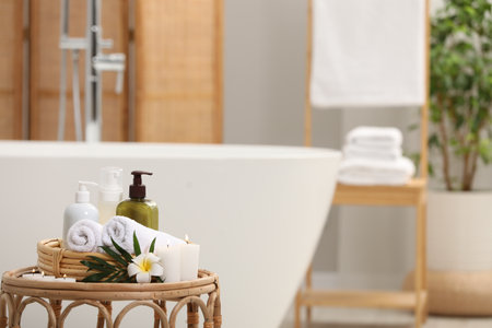 Spa products, burning candles, plumeria flower and tropical leaf on table in bathroom. Space for textの写真素材