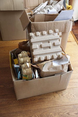 Reuse concept. Different trash in cardboard boxes for recycling on floor indoors