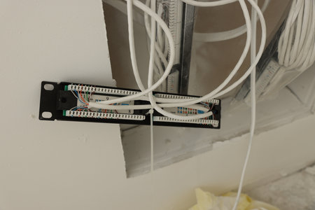 Many electric wires on white wall, closeup