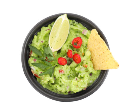 Delicious guacamole served with nachos chips, lime and pepper isolated on white, top viewの写真素材