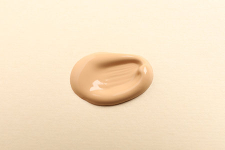 Sample of skin foundation on beige background, top viewの写真素材