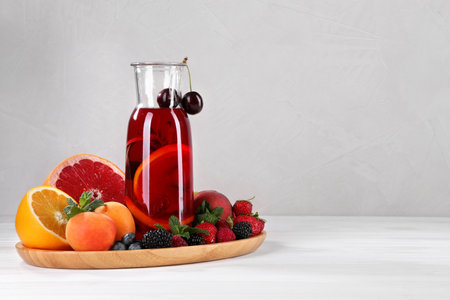Delicious refreshing sangria, fruits and berries on white wooden table, space for textの写真素材