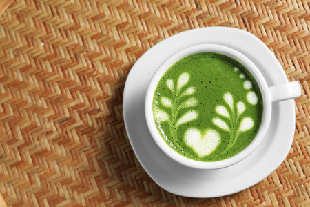 Delicious matcha latte in cup on wicker table, top view. Space for textの写真素材