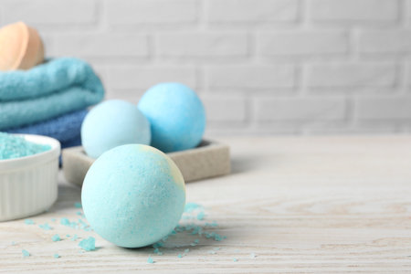 Beautiful aromatic bath bombs and sea salt on light wooden table. Space for textの写真素材