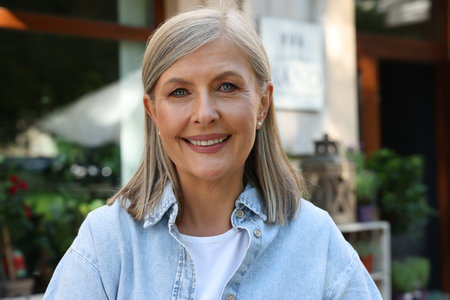 Portrait of happy business owner near her flower shop outdoors