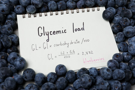 Notebook with calculated glycemic load for blueberries surrounded by fresh berries, closeupの写真素材