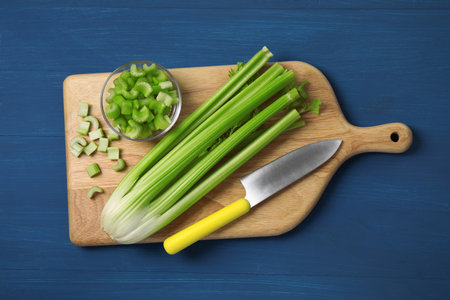 Fresh cut and whole celery on blue wooden table, top viewの写真素材