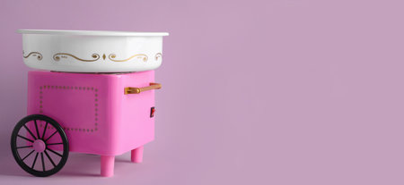 Portable candy cotton machine on pink background. Banner design with space for textの写真素材