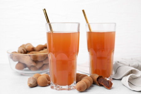 Tamarind juice and fresh fruits on white tableの写真素材