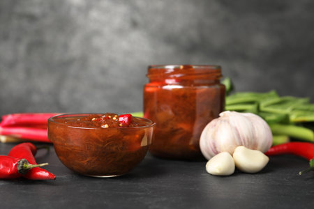 Tasty rhubarb sauce and ingredients on black table, space for textの写真素材