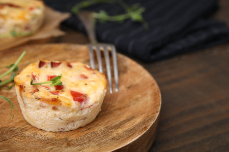 Delicious egg muffin with cheese and bacon on wooden table, closeup. Space for textの写真素材