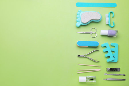 Set of pedicure tools on light green background, flat lay. Space for textの写真素材